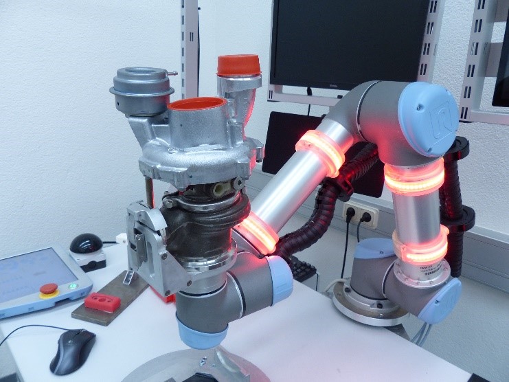 Frau arbeitet mit einem Roboterarm in einem Labor.